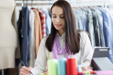Moda tasarımcısı kadın yakın plan elbise çizimi yapıyor.