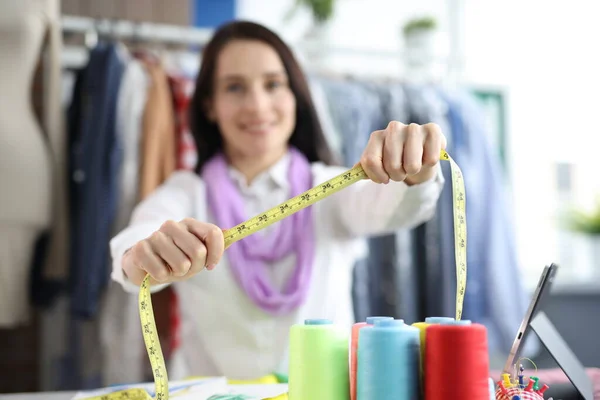 Mujer costurera sostiene centímetro para tomar medidas en el taller — Foto de Stock