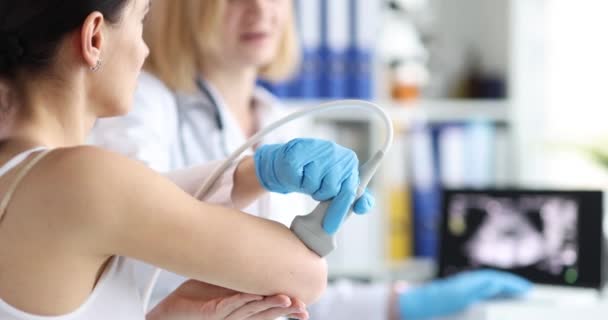 Dokter maken echografie van elleboog gewricht naar vrouw patiënt in kliniek 4k film — Stockvideo