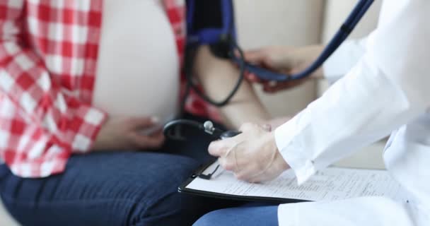Médico que mede a pressão arterial para mulher grávida closeup 4k movi — Vídeo de Stock