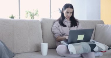 Kadın dikkatle dizüstü bilgisayara bakar ve sevinmeye başlar.