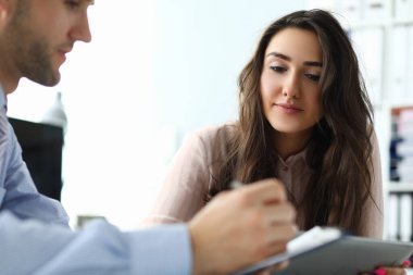 İki yönetici iş belgelerini incelerken ofiste iletişim kuruyor