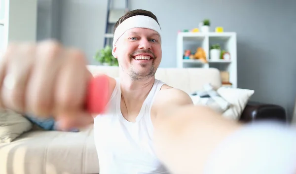 Joven haciendo ejercicios con mancuernas sonriendo a la cámara —  Fotos de Stock