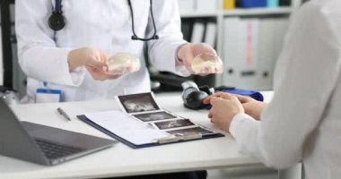 Hasta estetik cerrah randevusu sırasında silikon göğüs implantlarını inceliyor.