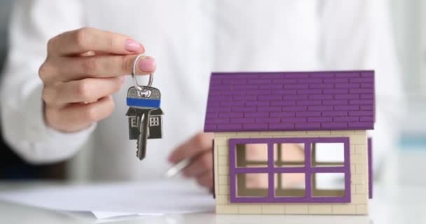 Agent ubezpieczeniowy lub pośrednik nieruchomości trzyma klucz zbliżenie — Wideo stockowe