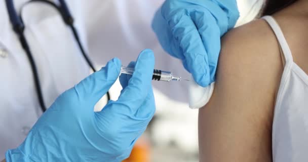 El médico con guantes sostiene la jeringa con la vacuna e inyecta al paciente en el hombro — Vídeos de Stock
