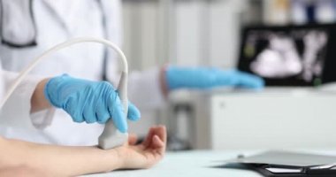 Doktor klinikte kol ultrasonu yapıyor.