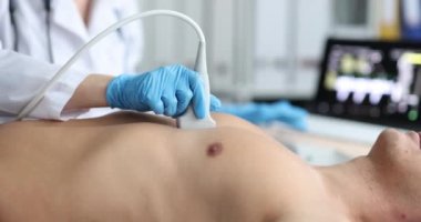 Doktor ve erkek hasta hastanede ultrason cihazları üzerinde çalışıyor.