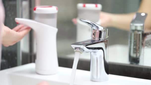 Person washes hands from automatic soap dispenser in bathroom closeup — Stock Video