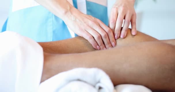 Massagista faz massagem na canela para atleta no salão de spa close-up — Vídeo de Stock
