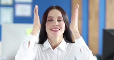Genç, gülümseyen kadın kulaklarını elleriyle kapatır ve şarkı söyler.