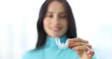 Kadın elleri şeffaf plastik dizginleri takıyor.