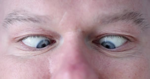 Ung man med blå ögon gör ögonövningar närbild — Stockvideo