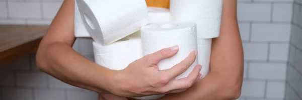 Kvinna som håller många rullar toalettpapper i badrum närbild — Stockfoto