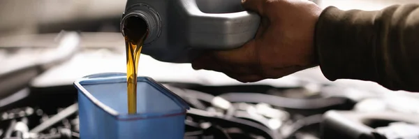 Foreman pours car oil into engine through watering can closeup — Stock Photo, Image