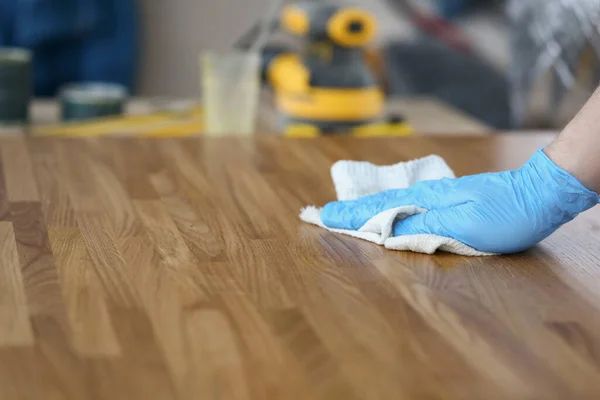 Carpentiere maschio lucidare tavola di legno con panno, lavoratore rimuovere la polvere dalla superficie di legno — Foto Stock