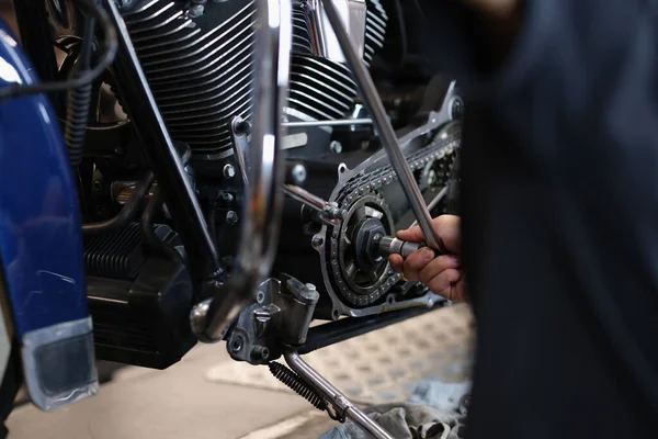 Handyman monteur reparatie van een deel van de motorfiets vervoer met moersleutel apparatuur — Stockfoto