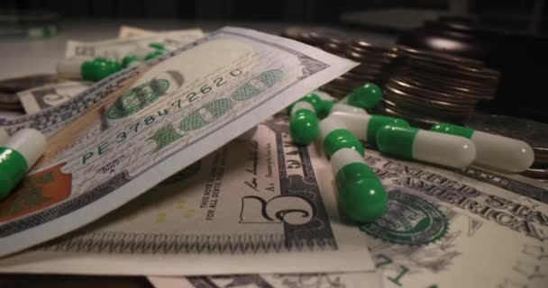 Dollar biljetten en munten liggen tussen medische capsules closeup 4k film — Stockvideo