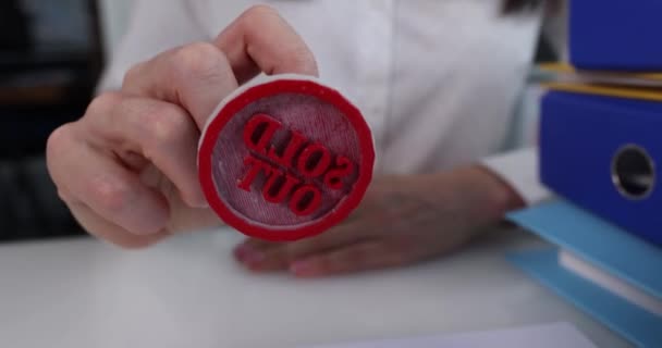 Vrouw hand zetten rode stempel uitverkocht op document closeup 4k film — Stockvideo