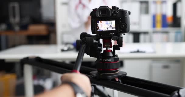 Fotograaf filmen arts op camera met behulp van statief en slider closeup 4k film — Stockvideo