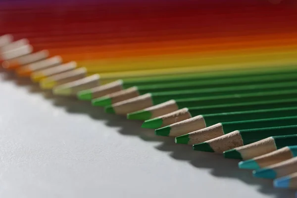 Färgade pennor ligger i rad på bordet, suddig — Stockfoto
