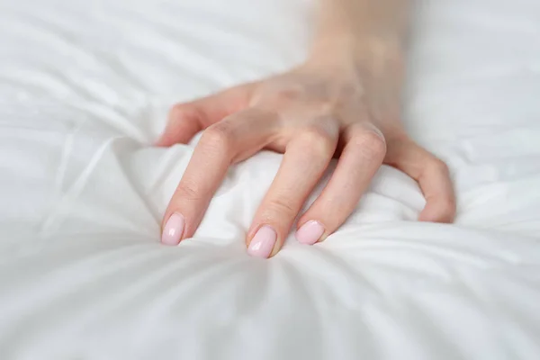 Una mano de mujer está apretando una manta en la cama —  Fotos de Stock
