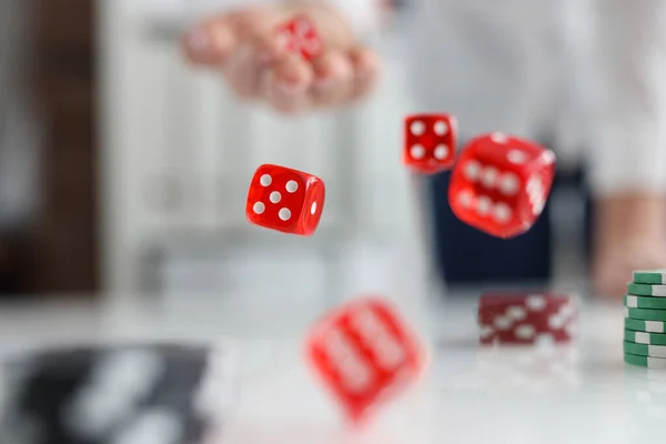En la mesa hay dados rojos y fichas de casino verde — Foto de Stock