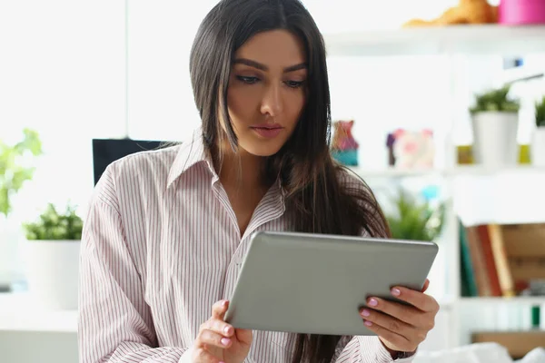 La señora concentrada mira en la pantalla de la tableta, trabaja desde casa, resuelve remotamente la tarea de trabajo — Foto de Stock