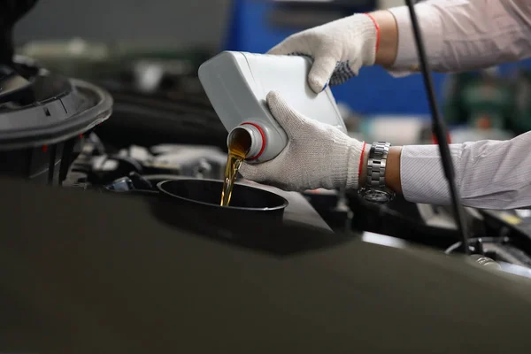Hombre en guantes de repostaje y verter nuevo aceite fresco en el motor de automóviles — Foto de Stock
