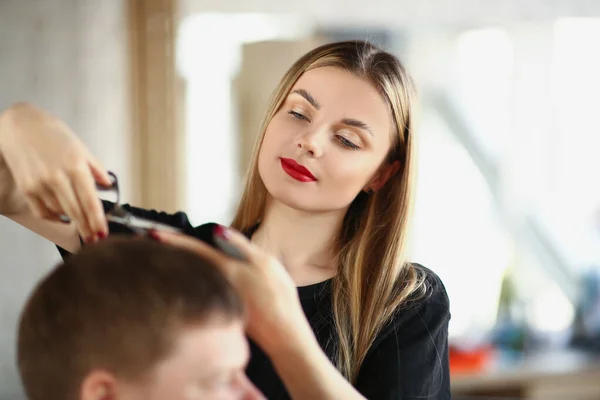 Una bella donna taglia un mans capelli con le forbici, primo piano — Foto Stock