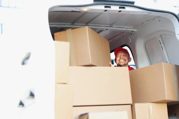 Lachender Postbote hinter Kisten im LKW, Nahaufnahme — Stockfoto