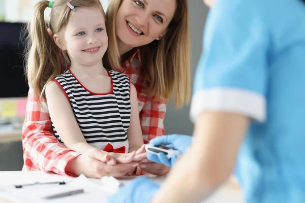 Медсестра здає аналіз крові з пальця маленької дівчинки — стокове фото