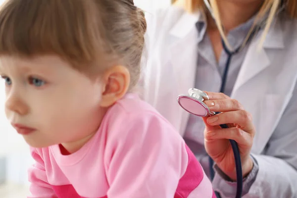 Liten flicka undersöks av barnläkare kvinnlig, lugn barn tålmodigt väntar på möte — Stockfoto