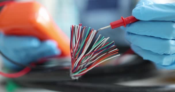 Électricien en gants comme testeur teste des fils électriques multicolores — Video