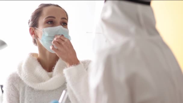 Doutor em terno de proteção toma cotonete do nariz do paciente em casa — Vídeo de Stock