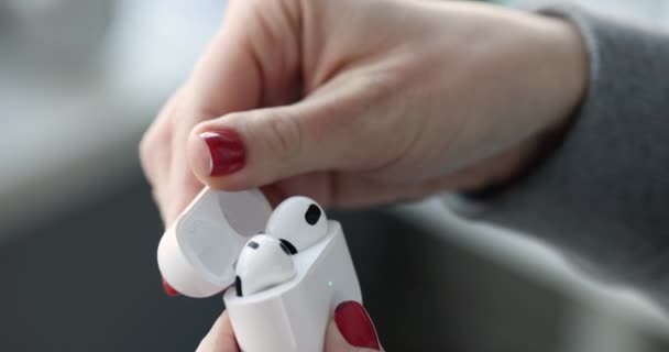 Kobieta wyciąga słuchawki bezprzewodowe z pudełka zbliżenie 4k movi — Wideo stockowe