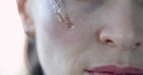 Mulher aplicando soro anti-envelhecimento na pele do rosto closeup filme 4k — Vídeo de Stock