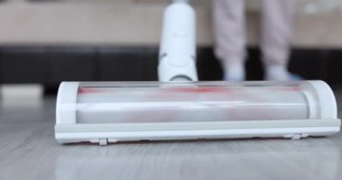 Temizlikçi kadın evdeki ahşap zemini süpürüyor. 4K film.