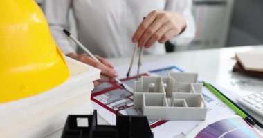 Mimarın yanında duran 3D model pusula ve kalem yakın plan 4K film.