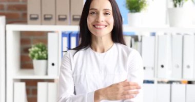 Elinde kırmızı steteskopla gülümseyen kadın doktor portresi. 4K film.