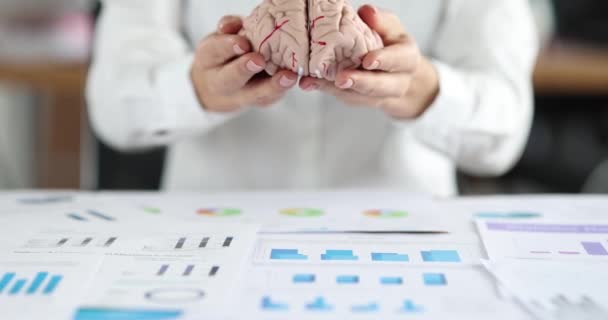 Διευθυντής τοποθέτηση ανθρώπινου εγκεφάλου σε έγγραφα με γραφήματα closeup 4k ταινία αργή κίνηση — Αρχείο Βίντεο