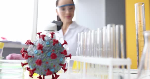 Ученый-химик изучает структуру молекулы коронавируса перед микроскопом в лабораторном фильме 4k — стоковое видео