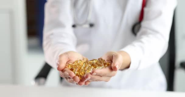 Medico tenendo tra le mani un sacco di gelatina gialla capsule mediche primo piano 4k film — Video Stock