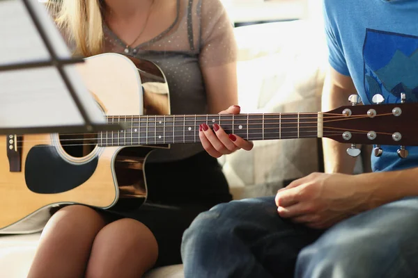 Professora explica notas ao cliente sobre instrumento de guitarra, aula de música em casa — Fotografia de Stock
