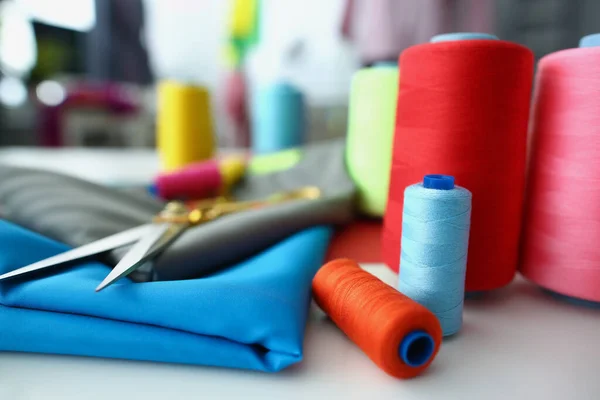 Accesorios de costura brillantes, tijeras e hilos en tela de algodón azul, espacio de trabajo creativo —  Fotos de Stock