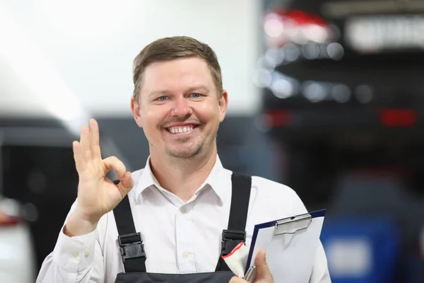 Trabajador de servicio de garaje mostrar signo ok con la mano y sonriendo felizmente en uniforme —  Fotos de Stock