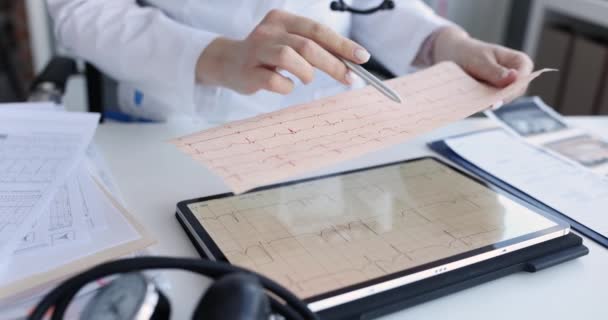 Cardiologista examina eletrocardiograma do paciente em close-up tablet — Vídeo de Stock