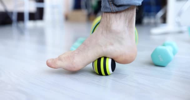 Männerbein rollt Sportball zur Vorbeugung und Behandlung von Plattfüßen Nahaufnahme — Stockvideo