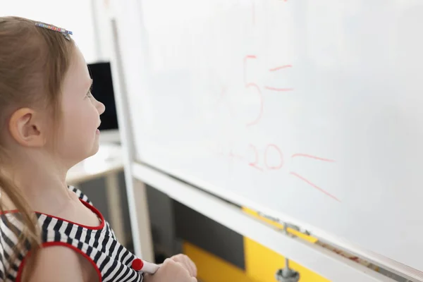 Maluch pisanie rozwiązanie sum na białej tablicy w szkole, proces edukacyjny — Zdjęcie stockowe