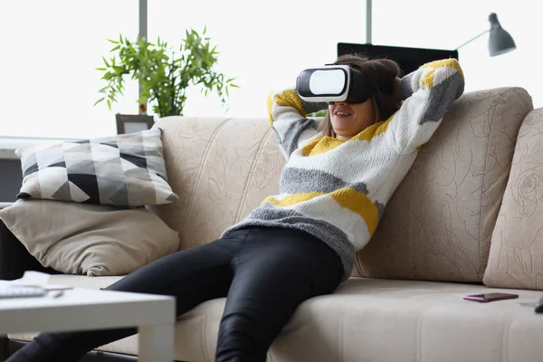 Feminino leigos casualmente no sofá em óculos VR, usar o dispositivo moderno em casa, testar o novo desenvolvimento — Fotografia de Stock